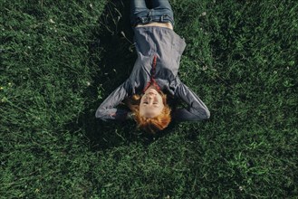 Caucasian teenage girl laying in grass