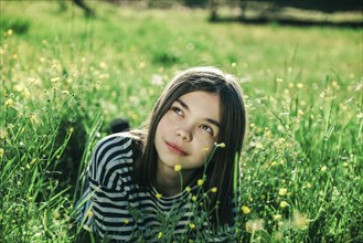 Smiling Caucasian teenage girl laying in grass