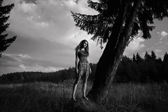 Caucasian woman standing in field near tree