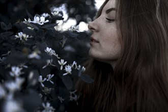 Caucasian woman smelling flowers outdoors