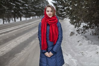 Smiling Caucasian woman standing near road in winter