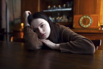Depressed Caucasian girl leaning on table