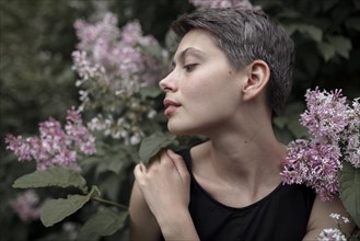 Profile of Caucasian woman standing in flowers