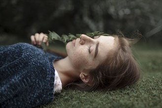 Caucasian girl with freckles laying in grass