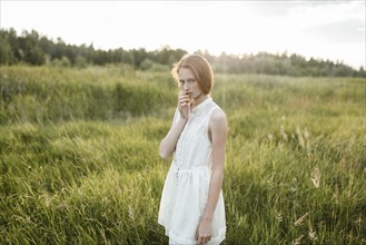 Portrait of pensive Caucasian girl standing in field