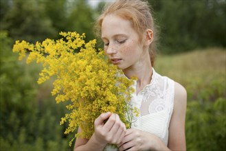 Caucasian girl smelling wildflowers