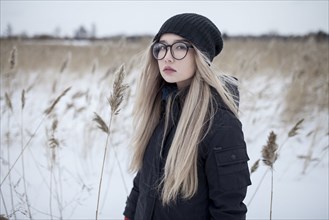 Serious Asian girl standing in field in winter