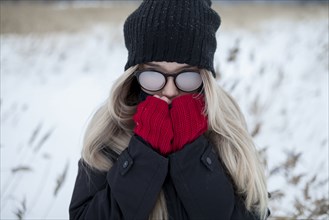 Cold Asian girl wearing a hat and eyeglasses in winter