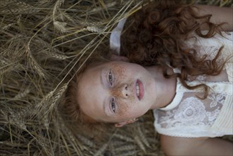 Caucasian girl laying in wheat