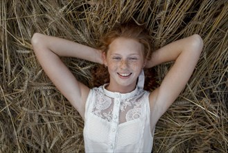 Caucasian girl laying in wheat