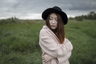 Asian woman standing in field