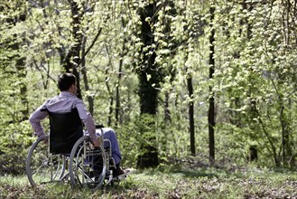 Man sitting in wheelchair in woods