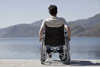 Caucasian man in wheelchair sitting on dock