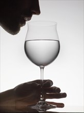 Man drinking water from wine glass
