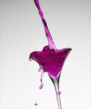 Pink liquid filling martini glass
