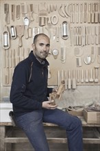 Carpenter holding wood in workshop