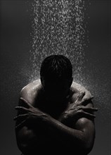Caucasian man sitting in shower