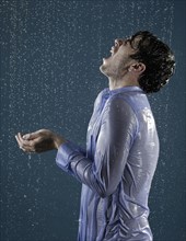 Caucasian man taking a shower in clothing