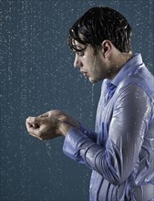 Caucasian man taking a shower in clothing