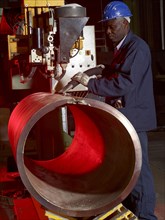 Worker working on steel pipe in factory