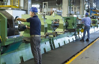 Caucasian workers working in steel factory