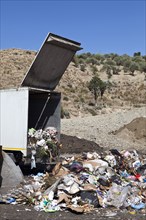 Truck dumping refuse into landfill