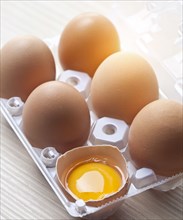 Close up of cracked egg in egg carton