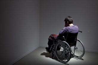 Frustrated Caucasian man in wheelchair in corner