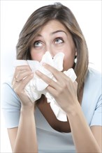 Woman blowing her nose into tissues