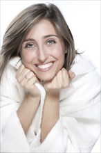 Smiling woman wrapped in bathrobe