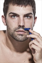 Caucasian man shaving his beard