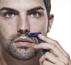Caucasian man shaving his beard