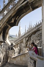 Caucasian mother and daughter photographing Milan Cathedral