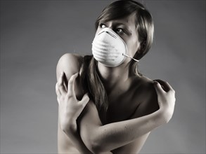Naked Caucasian woman wearing pollution mask