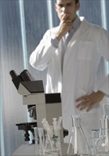 Pensive Caucasian scientist  standing in laboratory