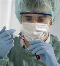 Caucasian scientist holding syringe and test tube
