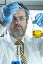 Caucasian scientist mixing liquid in laboratory
