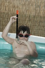 Caucasian boy wearing snorkel in inflatable swimming pool