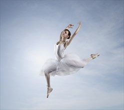 Caucasian ballerina dancing in sky