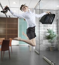 Caucasian businesswoman jumping in office