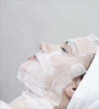 Caucasian woman receiving facial beauty treatment