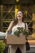 Laughing Caucasian carrying box with potted plant