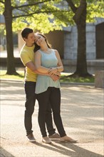 Caucasian couple hugging in park