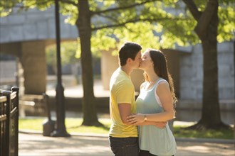 Caucasian couple kissing in park