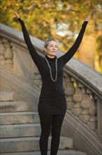 Caucasian woman meditating on staircase in park