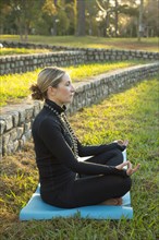 Caucasian woman meditating in park