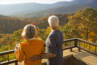 Older Caucasian couple enjoying wine and scenic view