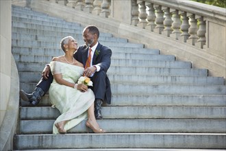 Black couple sitting on stone staircase