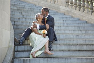 Black couple kissing on stone staircase