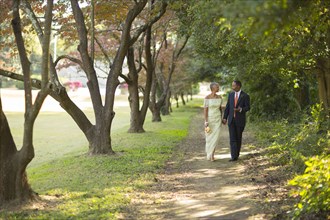 Black couple walking on path in park